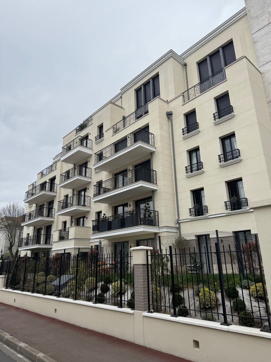 Immeuble résidentiel neuf en pierre de taille avec balcons en fer forgé, réalisation Batipose
