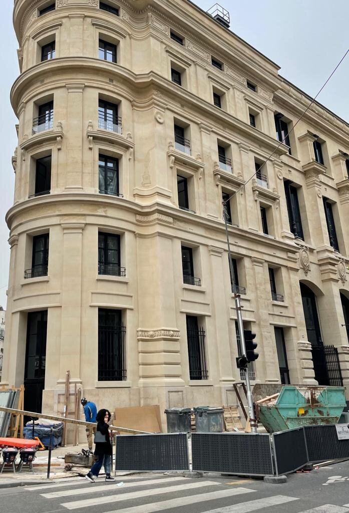 Immeuble en pierre de taille à l'angle de rue, façade restaurée à Paris