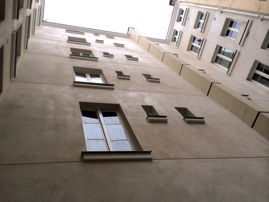 Façade en enduit traditionnel restaurée, cour intérieure parisienne